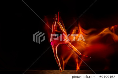 Young flexible female gymnast isolated on black studio background in mixed light, 69499462