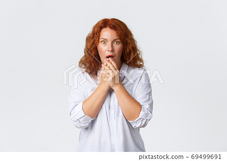 Shocked and amazed, gasping middle-aged redhead woman open mouth, cover mouth with hands and stare at camera impressed, gossiping, overhear interesting news, white background Shocked and amazed, gasping middle-aged redhead woman open mouth, cover mouth with hands and stare at camera impressed, gossiping, overhear interesting news, white background 69499691