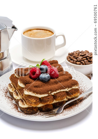 portion of Classic tiramisu dessert with raspberries and blueberries, cup of espresso and coffee maker isolated on white background with clipping path 69500761