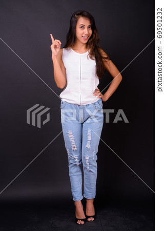 Young beautiful Asian woman against black background Young beautiful Asian woman against black background 69501232