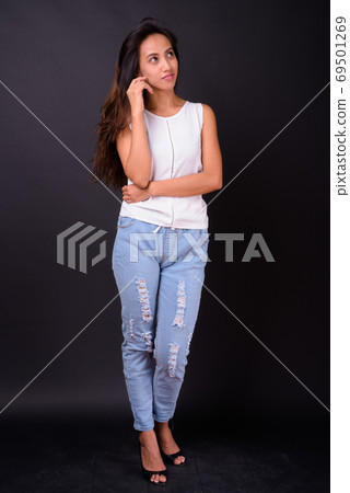 Young beautiful Asian woman against black background Young beautiful Asian woman against black background 69501269