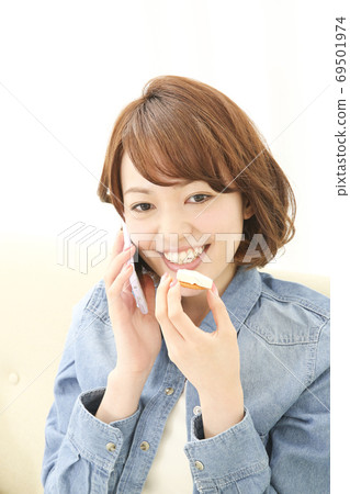 Woman eating while calling Woman eating while calling 69501974