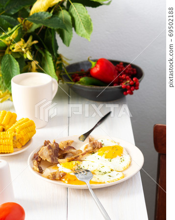 Fried eggs with bacon, hearty breakfast Fried eggs with bacon, hearty breakfast 69502188