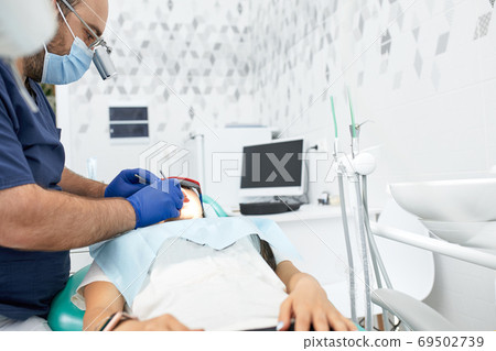 people, medicine, stomatology and health care concept - happy male dentist with woman patient at dental clinic office people, medicine, stomatology and health care concept - happy male dentist with woman patient at dental clinic office 69502739