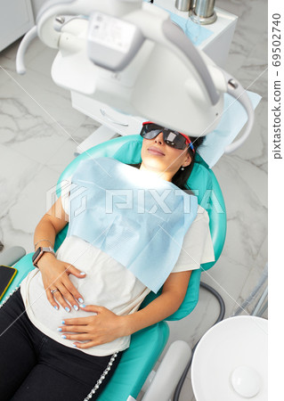 Overview of dental caries prevention.Woman at the dentist's chair during a dental procedure. Beautiful Woman smile close up. Healthy Smile. Beautiful Female Smile Overview of dental caries prevention.Woman at the dentist's chair during a dental procedure. Beautiful Woman smile close up. Healthy Smile. Beautiful Female Smile 69502740