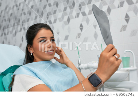 Overview of dental caries prevention.Woman at the dentist's chair during a dental procedure. Beautiful Woman smile close up. Healthy Smile. Beautiful Female Smile Overview of dental caries prevention.Woman at the dentist's chair during a dental procedure. Beautiful Woman smile close up. Healthy Smile. Beautiful Female Smile 69502742