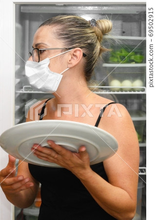 Young waitress with face protective mask working in restaurant. Coronavirus or Covid-19 concept. Young waitress with face protective mask working in restaurant. Coronavirus or Covid-19 concept. 69502915