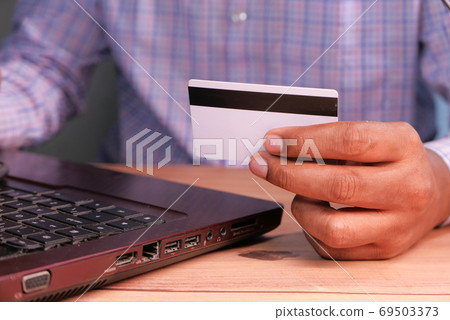 man hands holding credit card and using laptop shopping online man hands holding credit card and using laptop shopping online 69503373