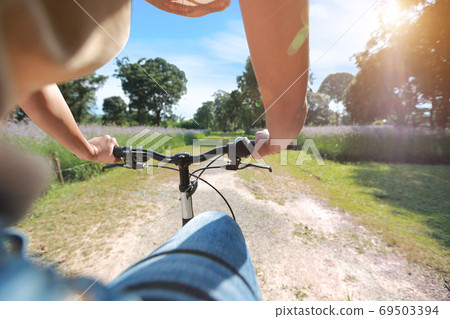 portrait of young beautiful and hipster woman riding bicycle and having fun among nature 69503394