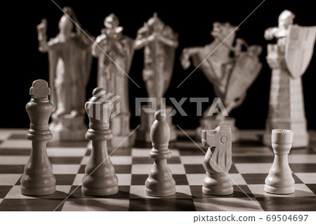 Classic white chess pieces and the same pieces in the form of medieval figures 69504697