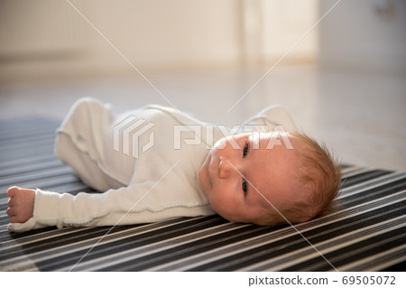 A little newborn baby lying on his back on striped monochrome sheet A little newborn baby lying on his back on striped monochrome sheet 69505072