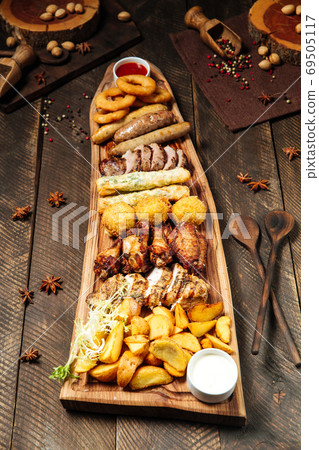 Fried beer snacks on the wooden board with sauces Fried beer snacks on the wooden board with sauces 69505117