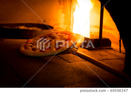 Close-up shot of hand made traditional italian pizza in wood fire oven Close-up shot of hand made traditional italian pizza in wood fire oven 69506347