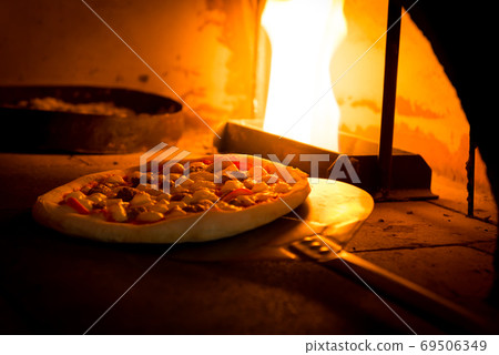 Close-up shot of hand made traditional italian pizza in wood fire oven Close-up shot of hand made traditional italian pizza in wood fire oven 69506349