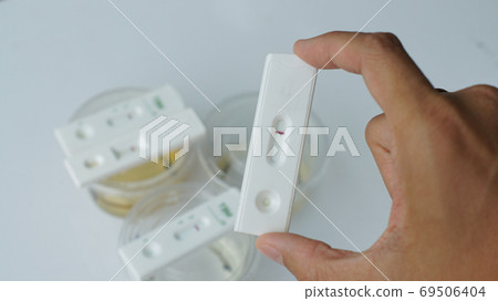 The human hand grabs the urine dropper methamphetamine detector. The human hand grabs the urine dropper methamphetamine detector. 69506404