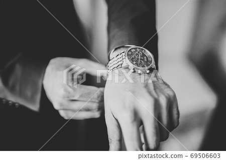 Grooms morning preparation. Handsome man getting dressed and preparing for the wedding 69506603