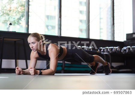 Woman doing push-UPS on the floor Woman doing push-UPS on the floor 69507863