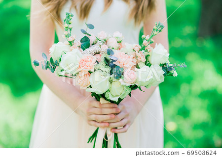 Wedding bouquet of white and red roses in bride's hands Wedding bouquet of white and red roses in bride's hands 69508624