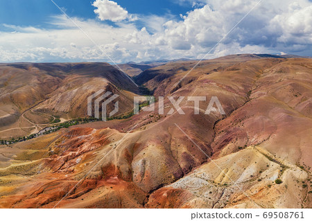 Aerial shot of the textured yellow nad red mountains resembling the surface of Mars Aerial shot of the textured yellow nad red mountains resembling the surface of Mars 69508761