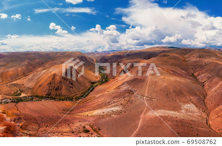 Aerial shot of the textured yellow nad red mountains resembling the surface of Mars Aerial shot of the textured yellow nad red mountains resembling the surface of Mars 69508762