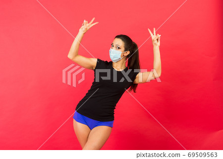 Young fitness woman in sportswear face mask isolated on red background studio. Motivation concept. Young fitness woman in sportswear face mask isolated on red background studio. Motivation concept. 69509563