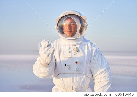 Astronaut in holding mineral crystal Astronaut in holding mineral crystal 69510449