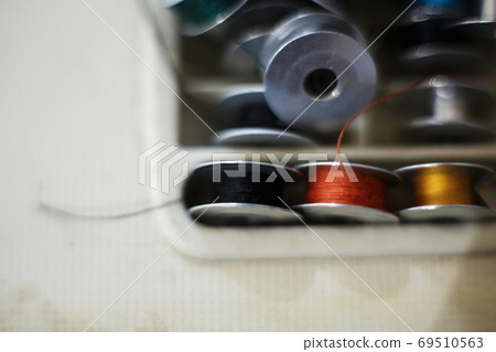 Closeup set of colored thread for a sewing machine. Workplace seamstress. Tailoring industry 69510563