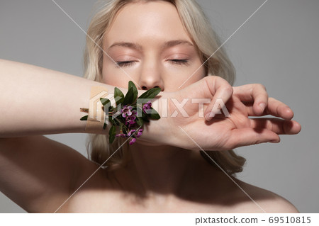 Beautiful young woman showing her hand with flowers 69510815