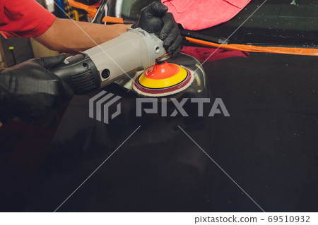 Hands with Auto polisher. Car repair service. 69510932