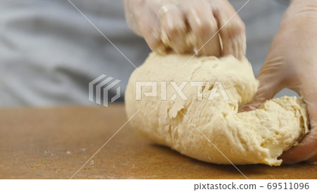 woman mother or daughter on the kitchen table makes domestic food pizza, hands work and pushing stir woman mother or daughter on the kitchen table makes domestic food pizza, hands work and pushing stir 69511096