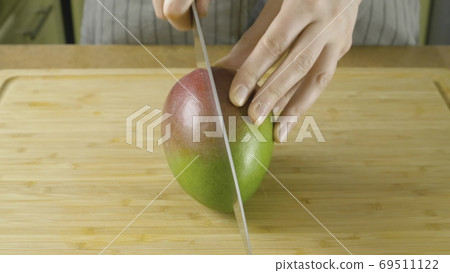 Woman hands unfolds cutted by pieces fresh yellow mango in close up video in 4K Woman hands unfolds cutted by pieces fresh yellow mango in close up video in 4K 69511122
