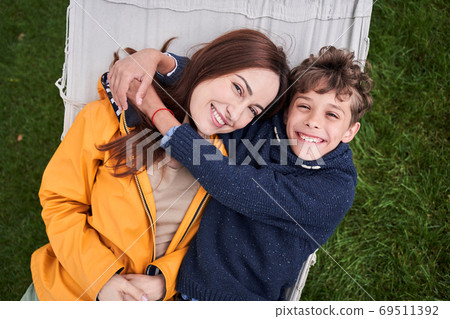Happy mother and son lying on hammock swing outdoors 69511392