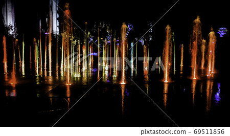 Illuminated water splash by night in Torun, Poland Illuminated water splash by night in Torun, Poland 69511856