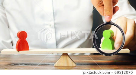 Wooden figures of people on scales and a mediator / arbitrator. Resolving conflict situations and disputes. Conclusions of the peaceful resolution of disputes. Conflict of interest. Business opponents 69512070