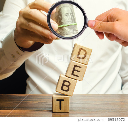 Businessman removes wooden blocks with the word Debt. Debt relief or cancellation is the partial or total forgiveness of debts, or the slowing or stopping growth. Restructuring. Pay. Selective focus Businessman removes wooden blocks with the word Debt. Debt relief or cancellation is the partial or total forgiveness of debts, or the slowing or stopping growth. Restructuring. Pay. Selective focus 69512072