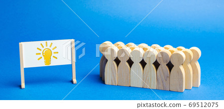 Business team and easel with the image light bulb of an idea. Generating Innovative Ideas. Creative business process. Strategy and Management. Teamwork concept Business team and easel with the image light bulb of an idea. Generating Innovative Ideas. Creative business process. Strategy and Management. Teamwork concept 69512075