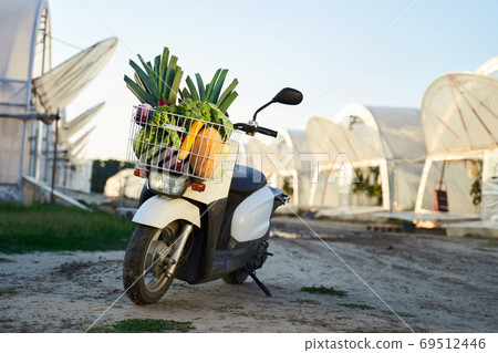 Scooter with fruits and vegetables in basket Scooter with fruits and vegetables in basket 69512446