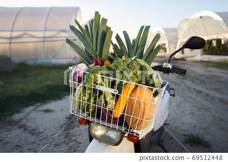 Scooter with fruits and vegetables in basket Scooter with fruits and vegetables in basket 69512448