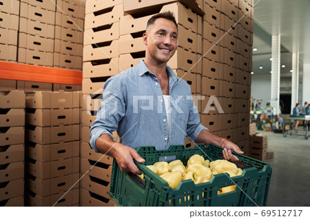 Worker with box in warehouse Worker with box in warehouse 69512717