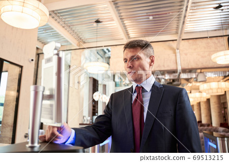 Handsome businessman making check-in at hotel 69513215