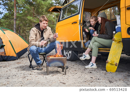 Handsome man lights a fire 69513428