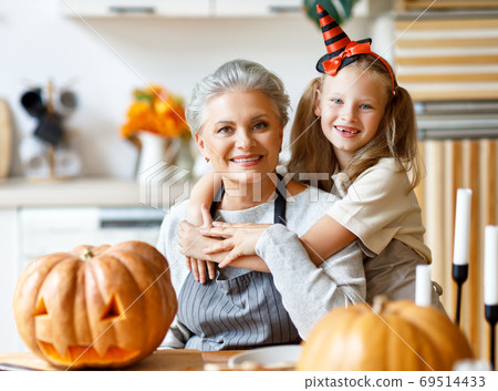 Happy granddaughter and grandmother preparing for Halloween cele 69514433