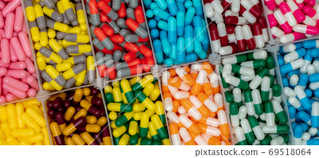 Colorful capsule pills in plastic box. Pharmaceutical industry. Colorful capsule pills in plastic box. Pharmaceutical industry. 69518064