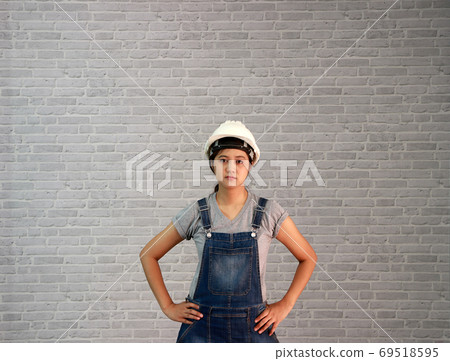 Technician woman ware white helmet with grey T-shirt and denim j Technician woman ware white helmet with grey T-shirt and denim j 69518595