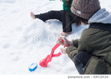 Parent and child playing in the snow 69519316