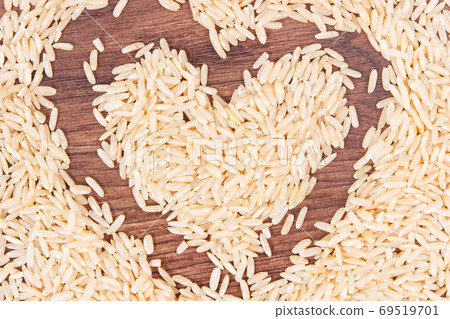 Heart shaped brown rice on rustic board Heart shaped brown rice on rustic board 69519701