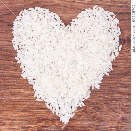 White rice in shape of heart on rustic board, healthy nutrition 69519702