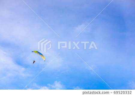 A flying paramotor on a vibrant sky with cloud. A flying paramotor on a vibrant sky with cloud. 69520332