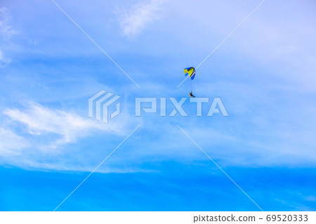 A flying paramotor on a vibrant sky with cloud. A flying paramotor on a vibrant sky with cloud. 69520333