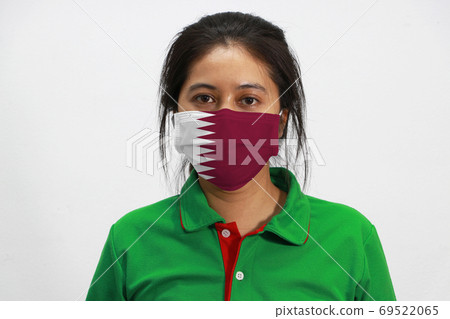 Qatar flag on hygienic mask. Masked asian woman prevent germs an 69522065